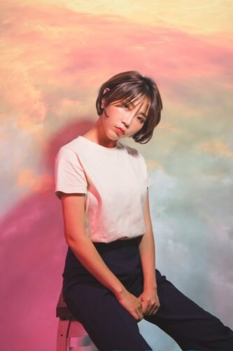 woman in white crew neck t shirt and black pants sitting on the chair