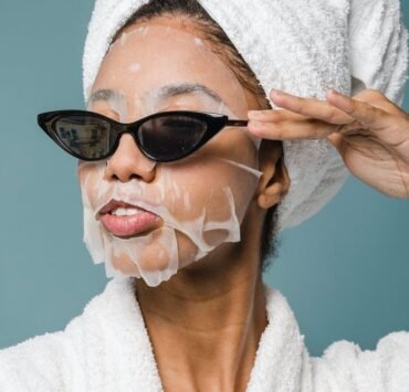 content young black woman wearing sunglasses during skin care treatment after bath