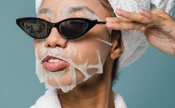 content young black woman wearing sunglasses during skin care treatment after bath