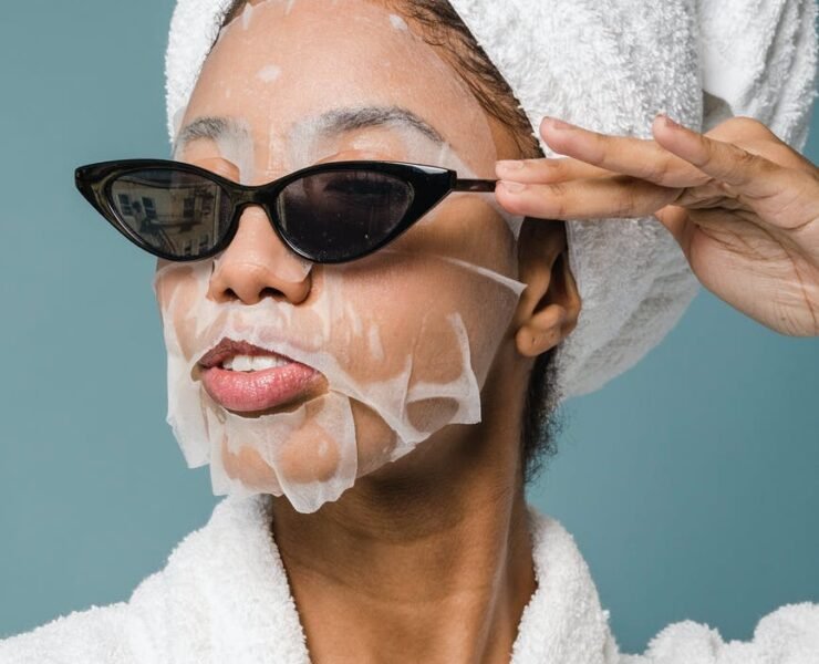 content young black woman wearing sunglasses during skin care treatment after bath