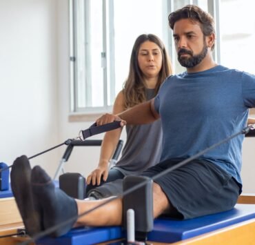 a man in blue shirt exercising with supervision
